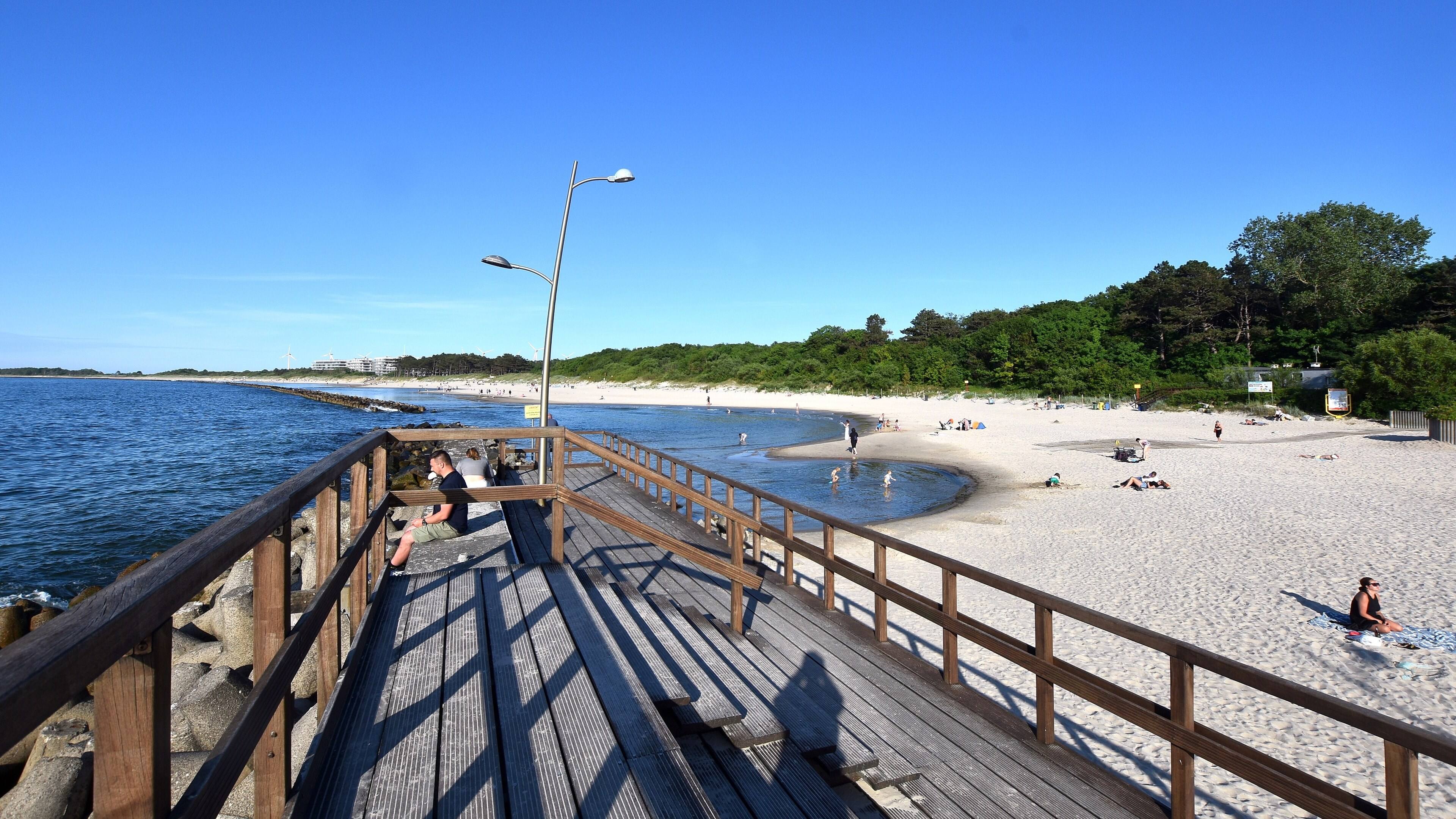Drewniany pomost nad plażą wschodnią w Darłówku, morze i pas sosnowego lasu